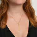 Gold birthflower name necklace with daffodil charm and script name on model