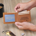 Hands opening a leather wallet with a personal engraved message near coffee and keys