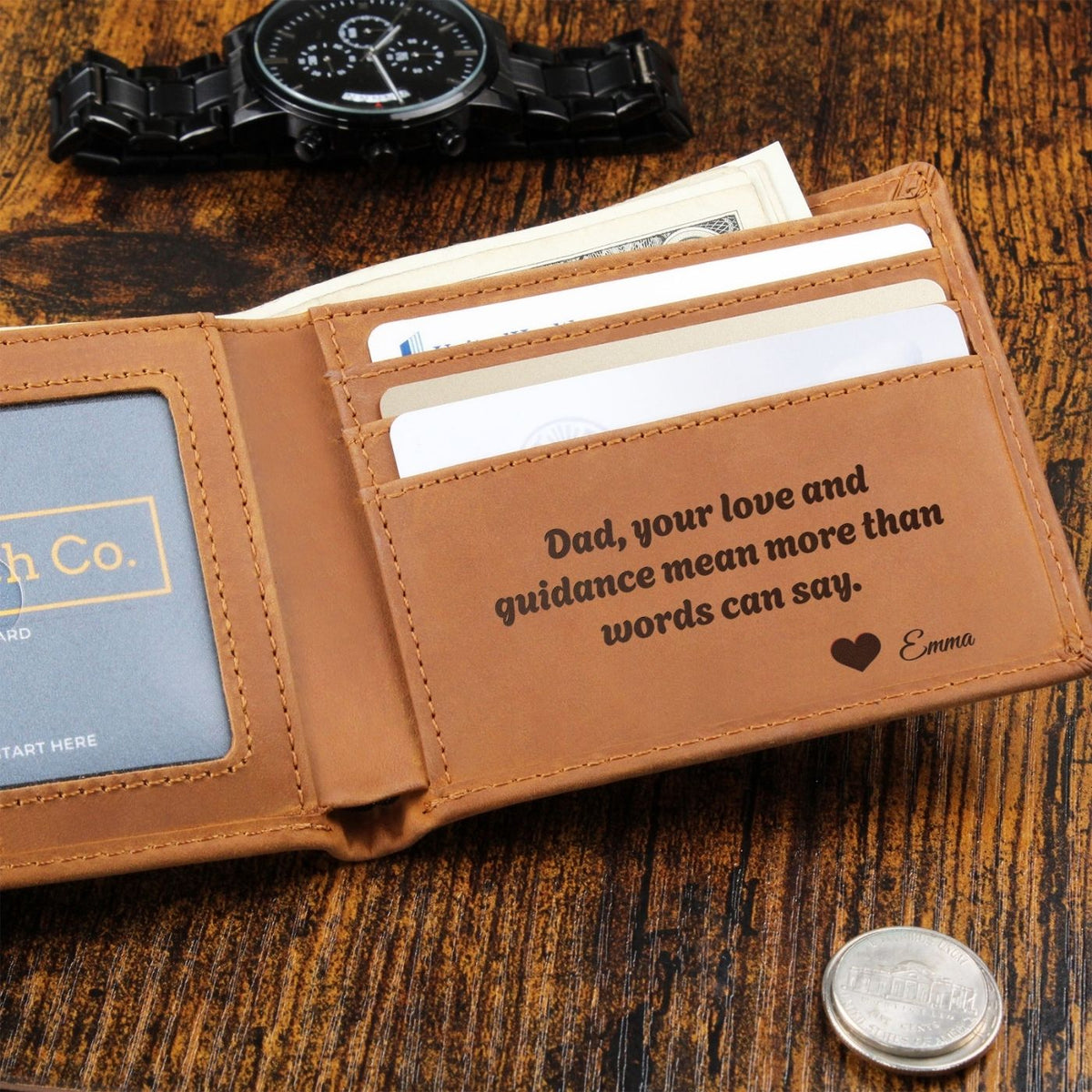 Open leather wallet with an engraved message beside a wristwatch and cash